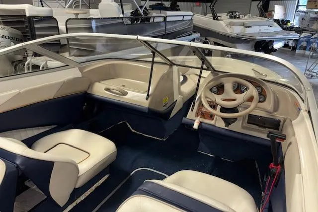 Slide: The Image of 1996 Bayliner 1700 LS boat interior with steering wheel and seating in showroom. - 10