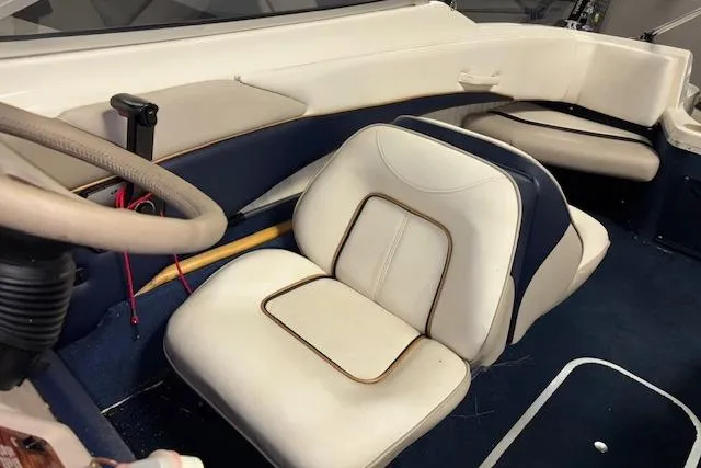 Slide: The Image of 1996 Bayliner 1700 LS boat interior with white and blue seating. - 12