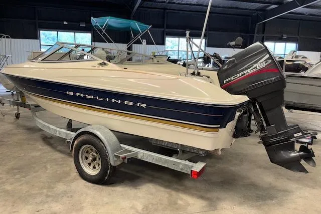 Slide: The Image of 1996 Bayliner 1700 LS boat on trailer in indoor storage facility. - 2