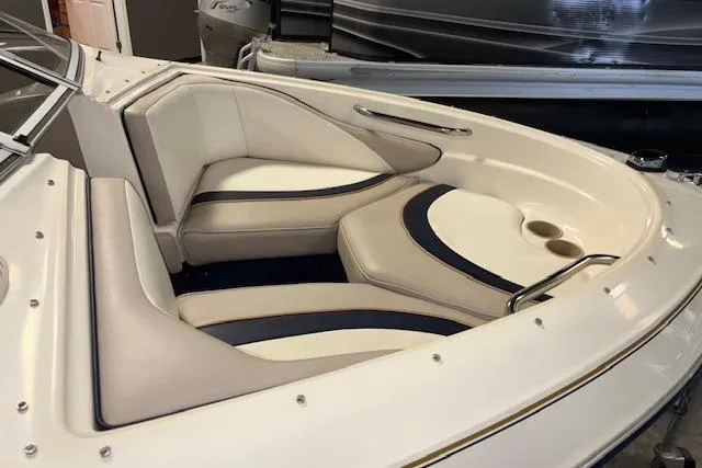 Slide: The Image of 1996 Bayliner 1700 LS boat interior with white and navy seating, cup holders. - 6