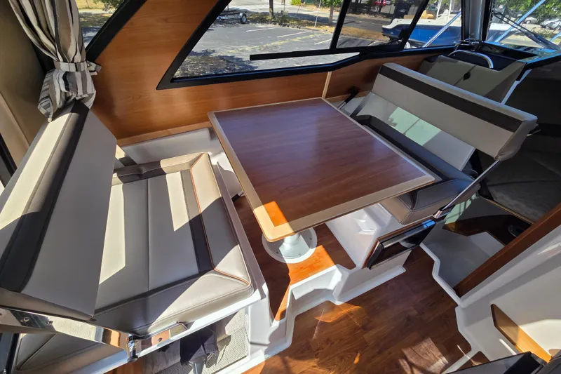 Slide: The Image of 2026 Cutwater C-248 Coupe interior with wood table and cushioned seating. - 10