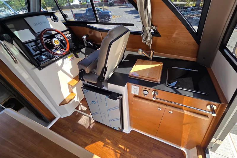 Slide: The Image of Interior of 2026 Cutwater C-248 Coupe featuring helm, kitchen, and wood accents. - 11