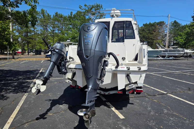 Slide: The Image of 2026 Cutwater C-248 Coupe boat with dual outboard motors in a parking lot. - 4