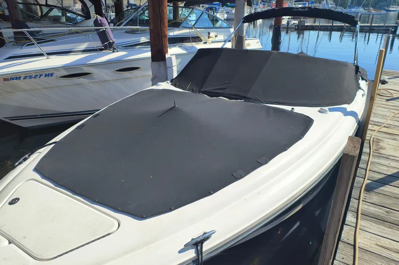 Slide: The Image of 2005 Sea Ray 270 SLX boat docked with black cover, marina background. - 11