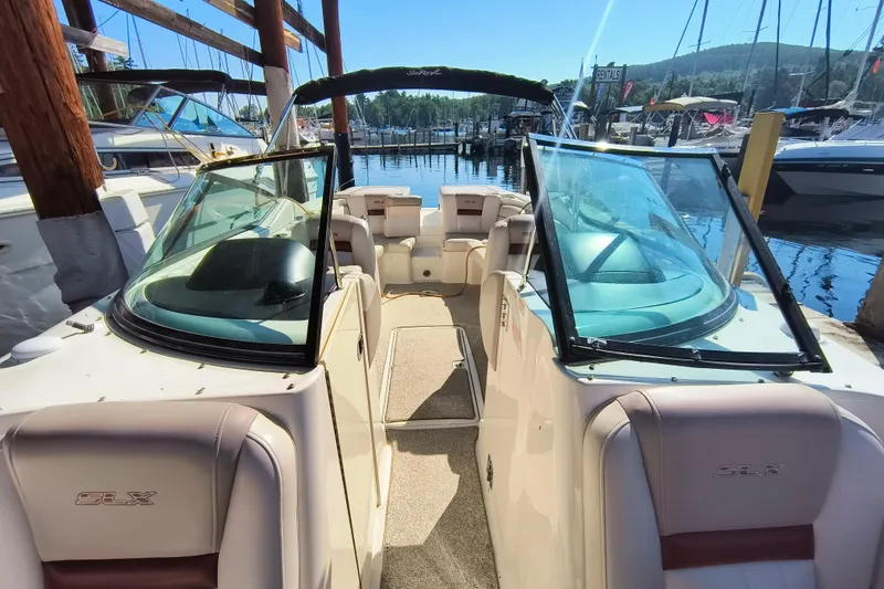 Slide: The Image of 2005 Sea Ray 270 SLX boat docked at marina, featuring open cockpit and dual windshields. - 2