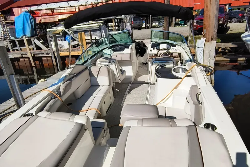 Slide: The Image of 2005 Sea Ray 270 SLX boat interior with seating and dashboard at a marina. - 7