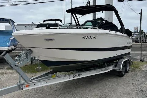 Slide: The Image of 2023 Chaparral 247 SSX boat on trailer, white exterior, parked outdoors. - 1