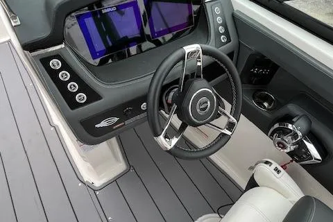 Slide: The Image of 2023 Chaparral 247 SSX boat dashboard with steering wheel and dual displays. - 10