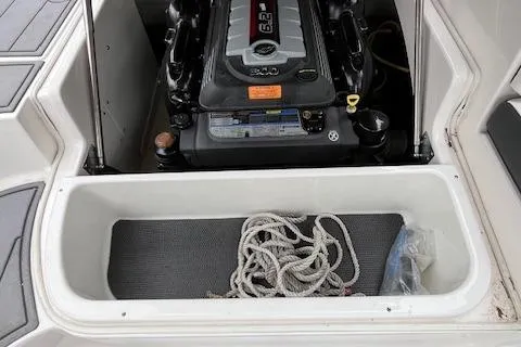 Slide: The Image of 2023 Chaparral 247 SSX boat engine compartment with storage area and rope. - 19