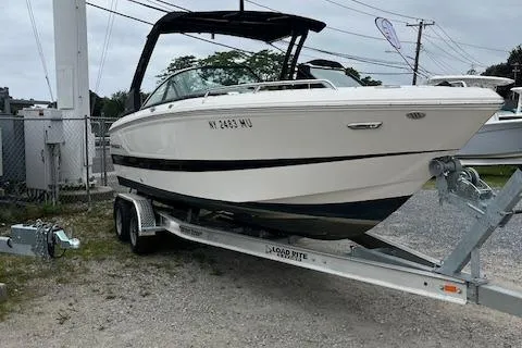 Slide: The Image of 2023 Chaparral 247 SSX boat on trailer, parked outdoors. - 2