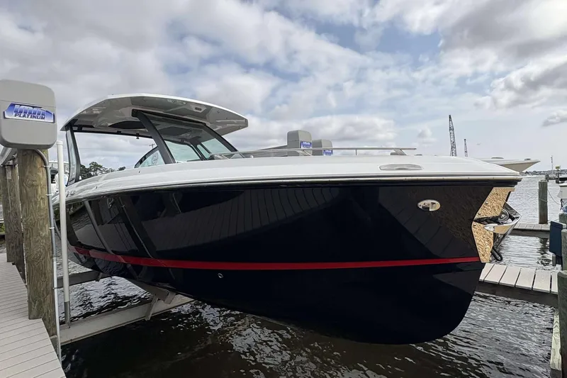 Slide: The Image of 2026 Monterey Elite 30 OB boat docked at marina under cloudy sky. - 2