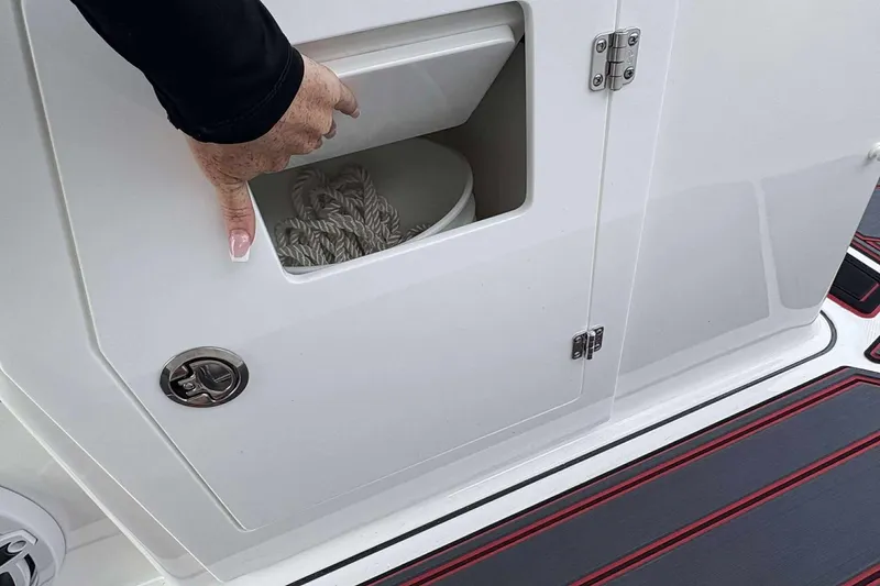 Slide: The Image of Hand accessing storage compartment on 2026 Monterey Elite 30 OB boat. - 20