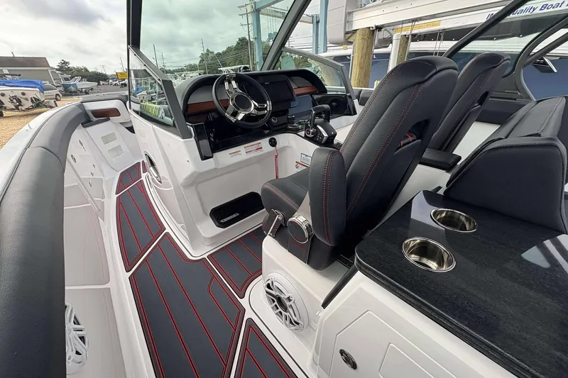 Slide: The Image of 2026 Monterey Elite 30 OB boat interior with sleek dashboard, black seats, and cup holders. - 25