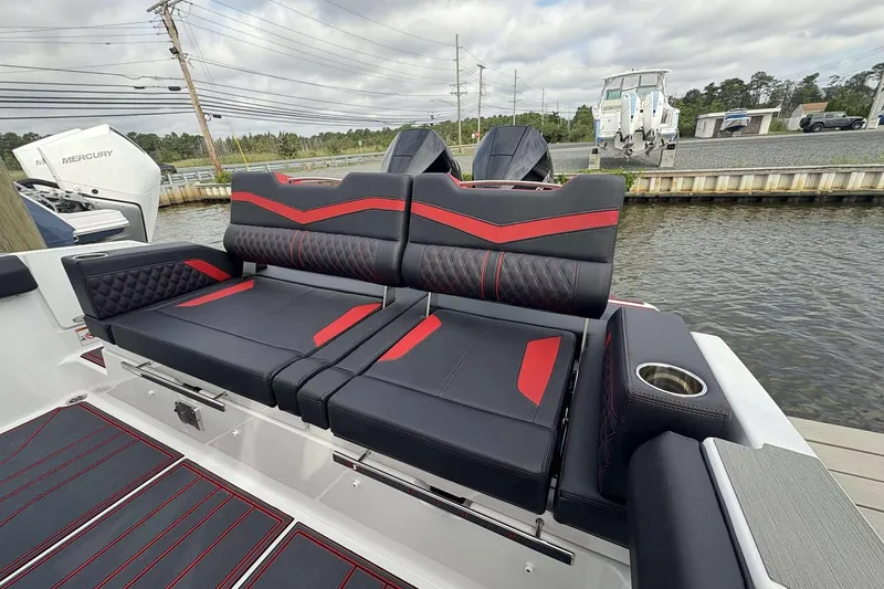 Slide: The Image of Luxurious seating on 2026 Monterey Elite 30 OB boat, featuring sleek black and red design. - 40