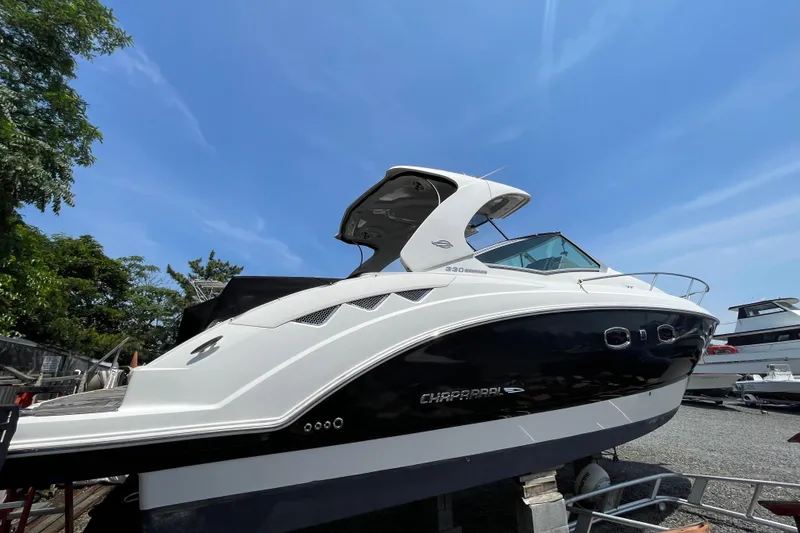 Slide: The Image of 2011 Chaparral 330 Signature boat on display under clear blue sky. - 2