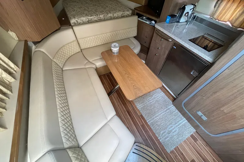 Slide: The Image of Interior of 2011 Chaparral 330 Signature boat with seating, table, and kitchenette. - 22