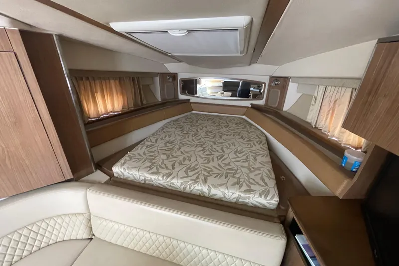 Slide: The Image of 2011 Chaparral 330 Signature cabin interior with bed, wood accents, and seating area. - 24