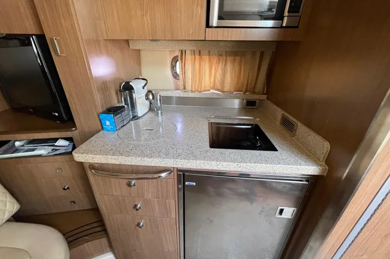 Slide: The Image of 2011 Chaparral 330 Signature yacht kitchenette with sink, microwave, and coffee maker. - 26