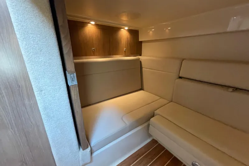 Slide: The Image of 2011 Chaparral 330 Signature cabin interior with beige seating and wooden accents. - 32