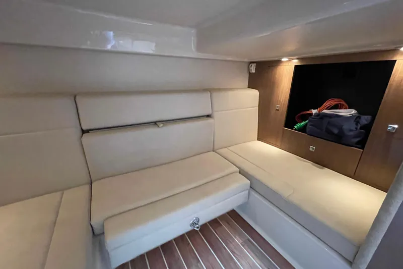 Slide: The Image of 2011 Chaparral 330 Signature cabin interior with beige seating and wooden accents. - 33
