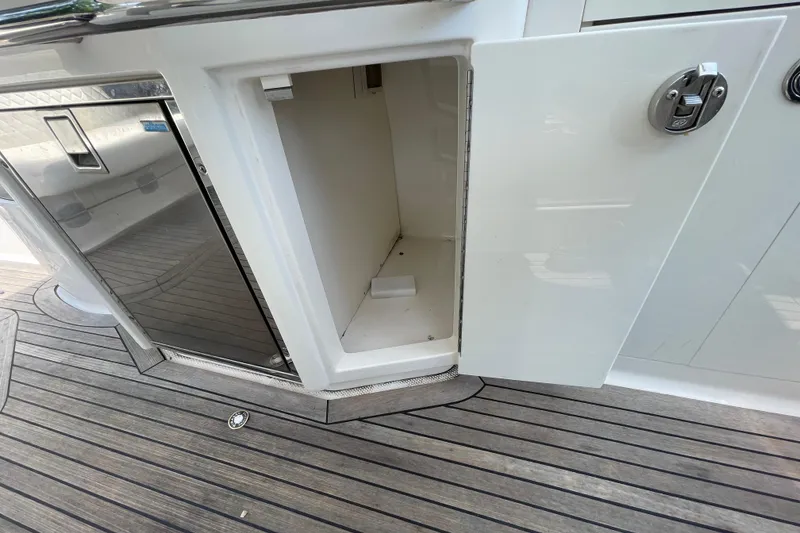 Slide: The Image of Open storage compartment on 2011 Chaparral 330 Signature boat with wooden deck flooring. - 38