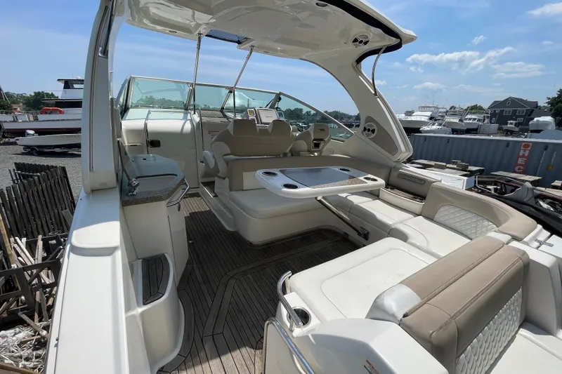 Slide: The Image of 2011 Chaparral 330 Signature boat interior with seating and table, docked under a clear sky. - 5