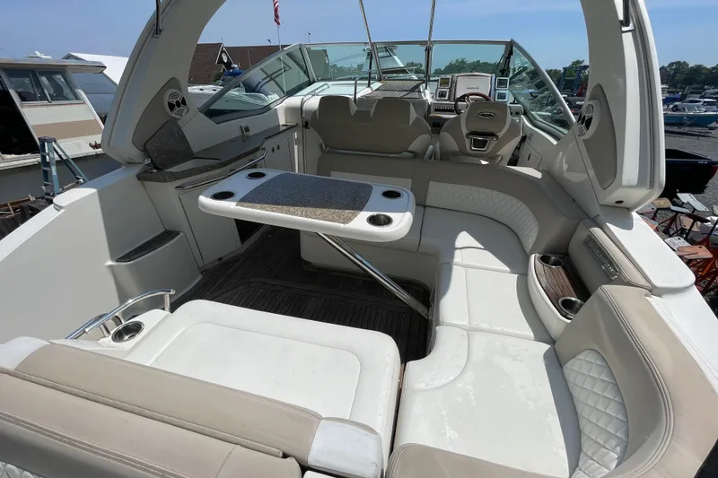Slide: The Image of 2011 Chaparral 330 Signature boat interior with plush seating and a central table. - 6