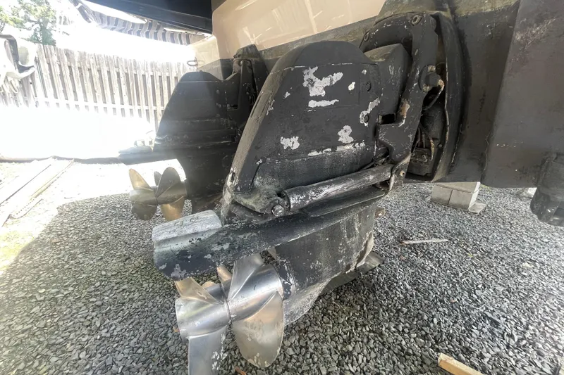 Slide: The Image of 2011 Chaparral 330 Signature boat propellers and stern drive on gravel surface. - 60