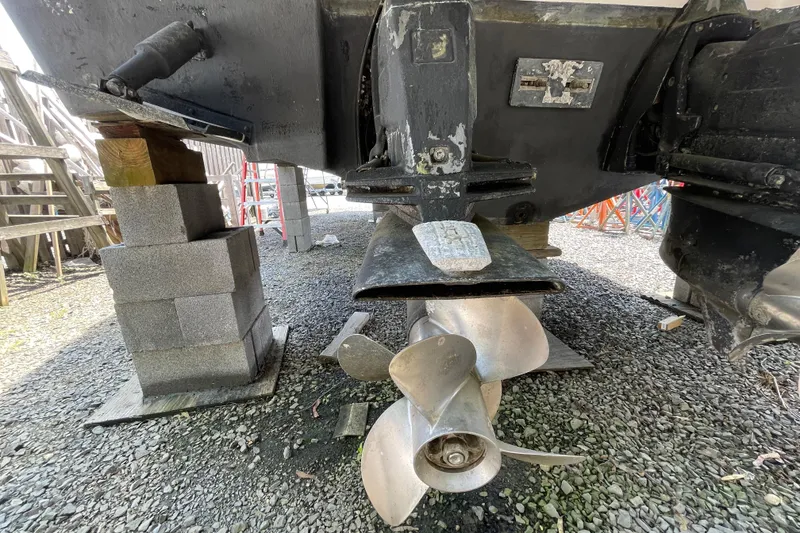 Slide: The Image of 2011 Chaparral 330 Signature boat propeller and stern drive on gravel, supported by blocks. - 62