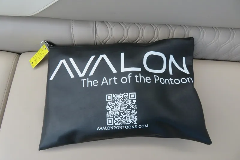 Slide: The Image of Black Avalon pouch on luxury boat seat, featuring QR code and branding. - 53