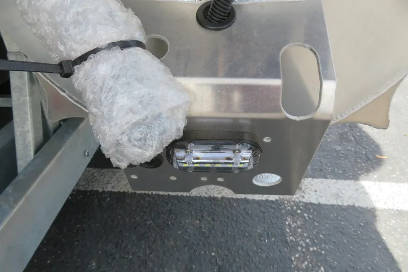 Slide: The Image of Close-up of Avalon 2385 LSZ Quad Lounger boat component, featuring bubble wrap and metal parts. - 14