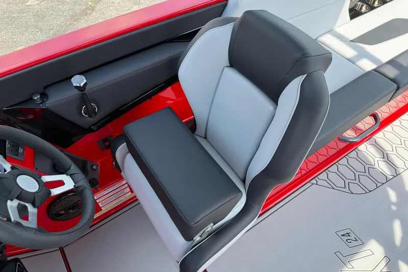 Slide: The Image of 2025 MasterCraft NXT24 boat interior with sleek black and gray seating and modern steering wheel. - 17
