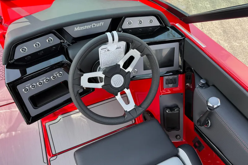 Slide: The Image of 2025 MasterCraft NXT24 boat dashboard with steering wheel and control panel. - 19