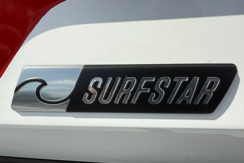 Slide: The Image of Surfstar emblem on 2025 MasterCraft NXT24 boat, featuring wave design on white surface. - 4