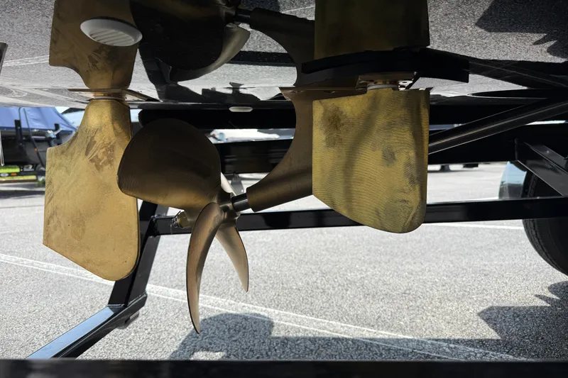 Slide: The Image of 2025 MasterCraft NXT24 boat propeller and rudder detail in a parking lot. - 7