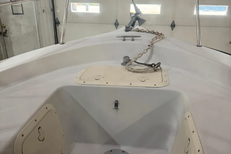 Slide: The Image of 2001 Adventure Craft 2800 Cabin Yacht bow with anchor chain in a garage setting. - 10