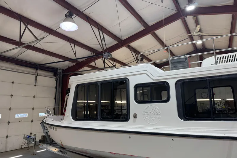 Slide: The Image of 2001 Adventure Craft 2800 Cabin Yacht in a garage, showcasing sleek design and windows. - 2