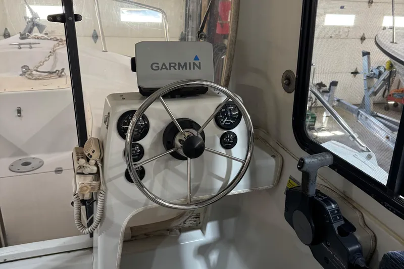 Slide: The Image of Steering wheel and controls of a 2001 Adventure Craft 2800 Cabin Yacht with Garmin navigation. - 6