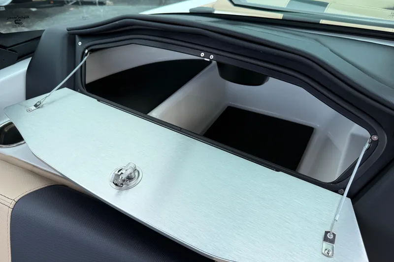 Slide: The Image of 2025 MasterCraft X24 boat storage compartment with open lid and latch. - 20