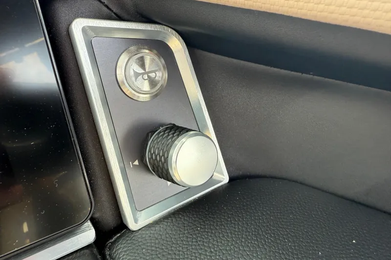 Slide: The Image of Control panel of 2025 MasterCraft X24 boat with sleek design and metallic knob. - 24