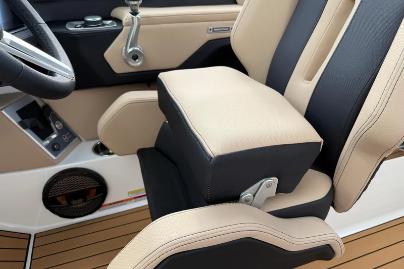 Slide: The Image of 2025 MasterCraft X24 boat interior with beige and black seating, steering wheel, and controls. - 25