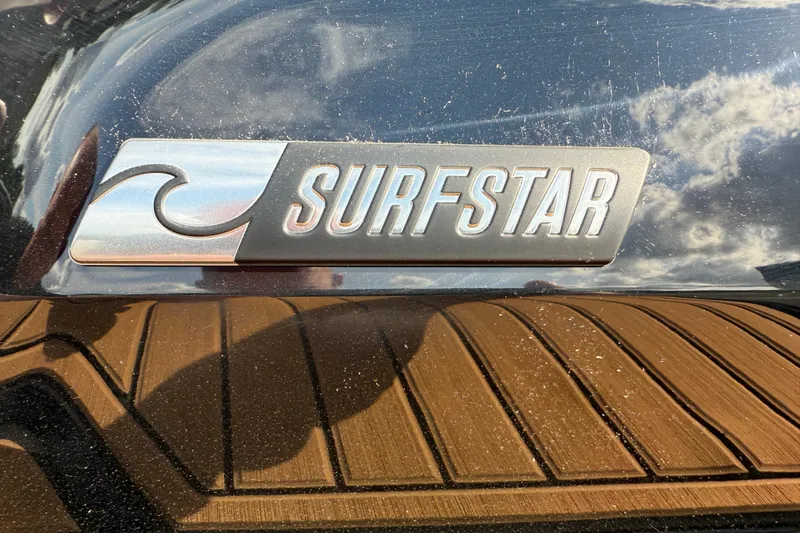 Slide: The Image of 2025 MasterCraft X24 SurfStar logo on boat with wooden deck reflection. - 33