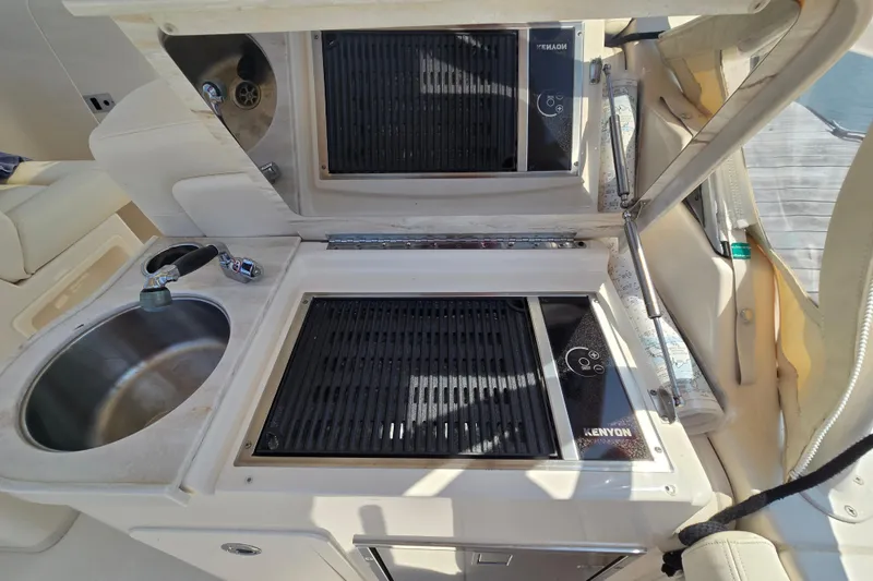 Slide: The Image of 2016 Grady-White Freedom 307 boat kitchen with sink and Kenyon grill. - 12