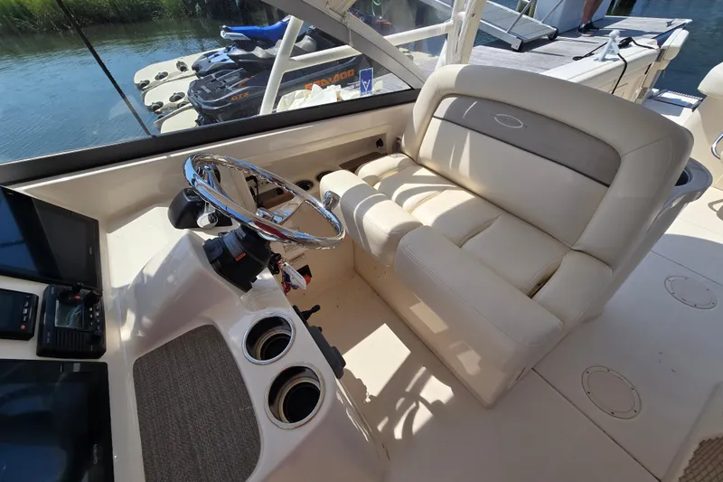 Slide: The Image of 2016 Grady-White Freedom 307 boat interior with steering wheel and seating. - 13