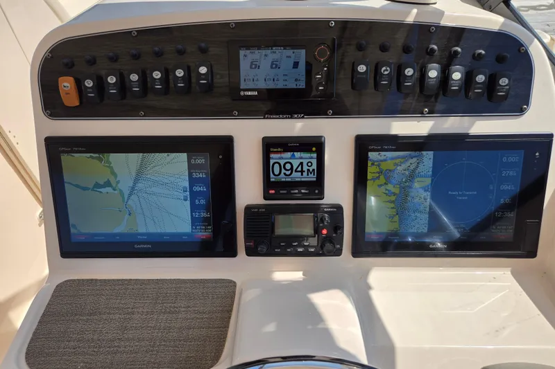 Slide: The Image of 2016 Grady-White Freedom 307 boat dashboard with Garmin navigation displays and controls. - 14