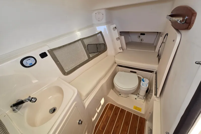 Slide: The Image of 2016 Grady-White Freedom 307 boat interior with sink, toilet, and seating area. - 17