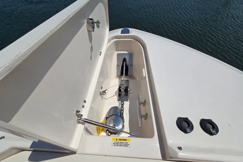 Slide: The Image of 2016 Grady-White Freedom 307 boat anchor compartment with open hatch, docked on water. - 21