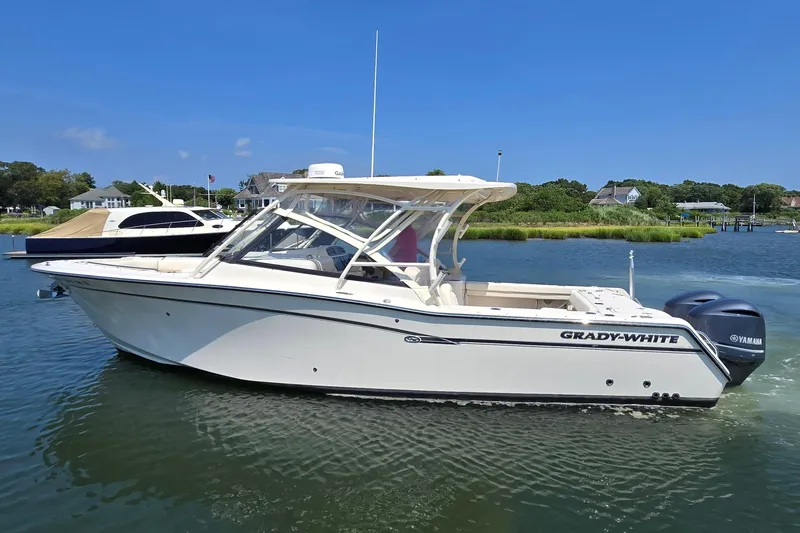 Slide: The Image of 2016 Grady-White Freedom 307 boat on calm water, clear sky background. - 5