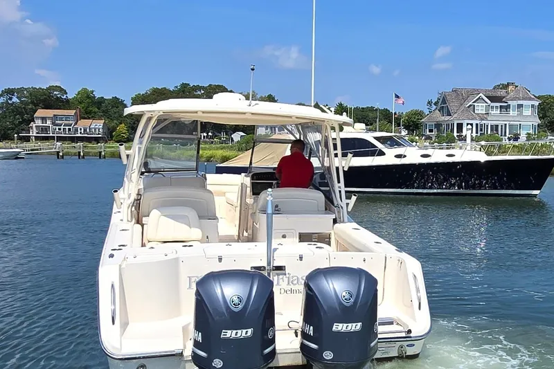 Slide: The Image of 2016 Grady-White Freedom 307 boat cruising in a scenic waterfront area. - 7