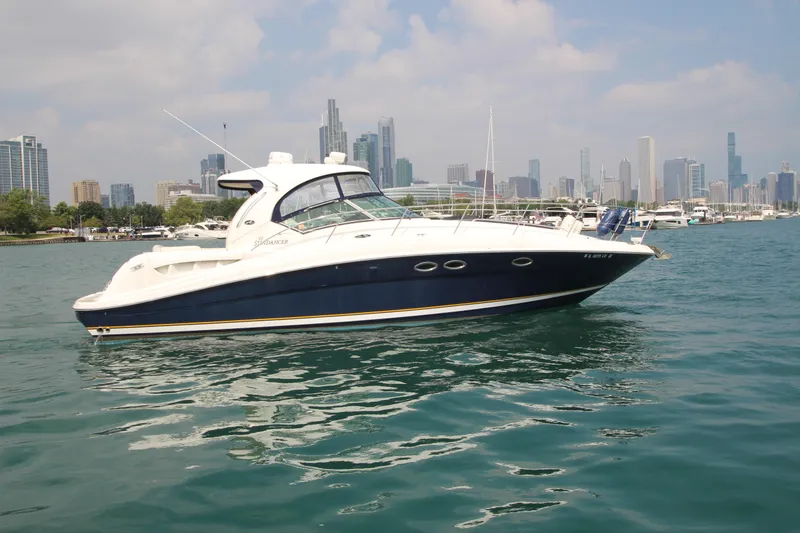 Slide: The Image of 2004 Sea Ray 40 Sundancer yacht on water with city skyline in background. - 0